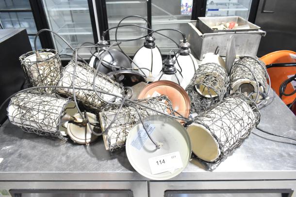 11 various light fixtures, metal and glass in varied designs. Includes wires. Tag reads "114 QTY". Good condition.