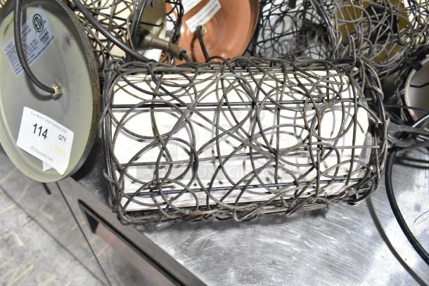 Alt text: Eleven assorted metal wire light fixtures with intricate designs. Each fixture is cylindrical with visible wiring and a metal base. Auction lot tag 114 displayed.