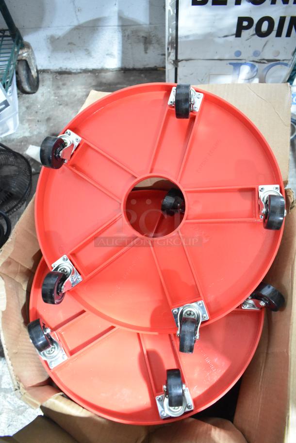 4 red poly round trash can dollies, each on commercial casters, in excellent condition, boxed ready for auction.