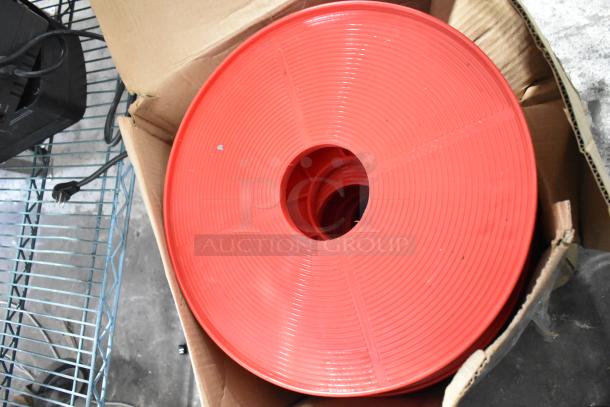 4 red poly round trash can dollies with commercial casters in good condition, stacked in a box.