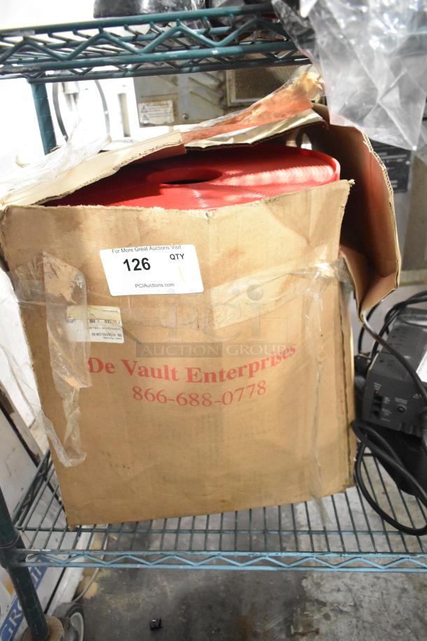 Box containing 4 red poly round trash can dollies with commercial casters, label reads "De Vault Enterprises 866-688-0778."