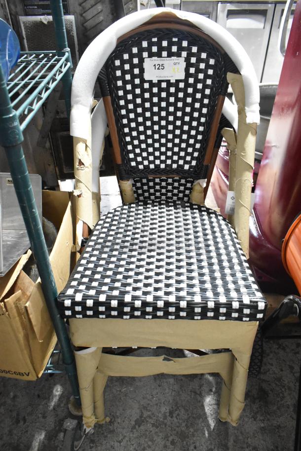 2 new Lancaster Bistro side chairs with black and white checkered weave, rattan frame, minor scratches, labeled for auction.