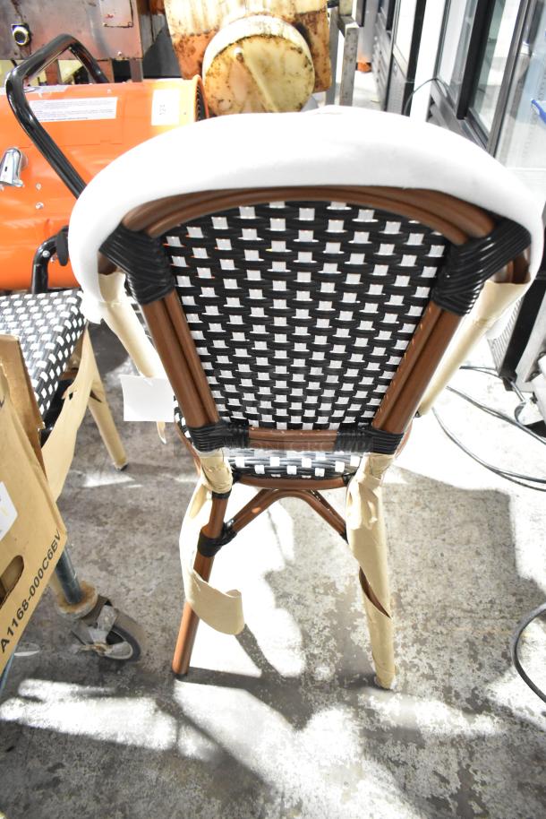 2 brand new Lancaster Table & Seating 427CSRTBSBKW Bistro chairs, black/white checkered rattan, outdoor use, scratch and dent condition.