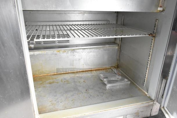 Beverage Air commercial sandwich salad prep table interior, showing storage area, wire rack, and visible wear.