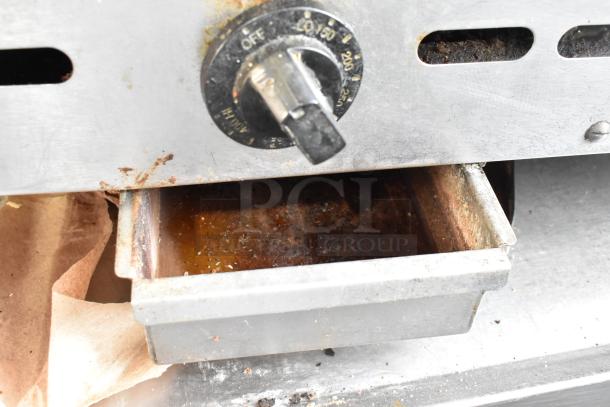 Bakers Pride commercial gas griddle with front control knob, grease tray, and stainless steel exterior showing signs of use.