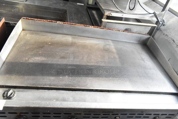 Bakers Pride commercial countertop gas griddle, flat top, steel construction, visible wear on surface, temperature dial.
