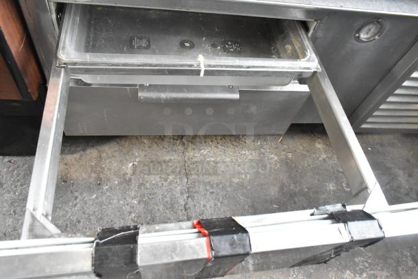 Commercial 2 Drawer Chef Base with stainless steel construction. Features visible wear. Includes spacious drawers.