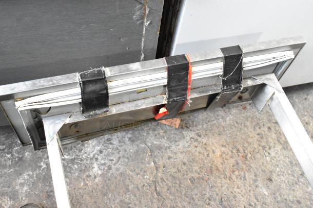 Commercial 2 Drawer Chef Base, metal construction, visible tape and wear, suitable for kitchen storage.