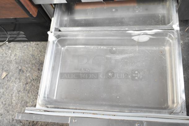 Commercial 2 Drawer Chef Base, stainless steel, showing open drawers with clear interior, slight wear visible.