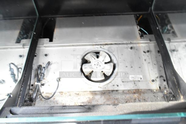 Structural Concepts floor-style grab-n-go merchandiser interior, showing ventilation fan and wiring, signs of wear.