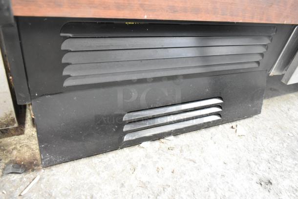 Structural Concepts commercial reach-in merchandiser, floor style, features vent detail, visible wear on base.