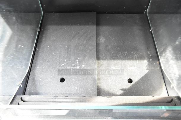 Structural Concepts commercial reach-in grab n go merchandiser interior, showing wear, glass panels, and base surface.