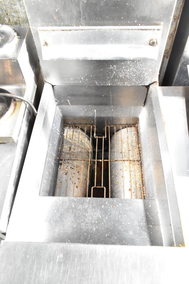 Frymaster commercial floor fryer with two metal fry baskets, showing internal heating elements, moderate wear visible.