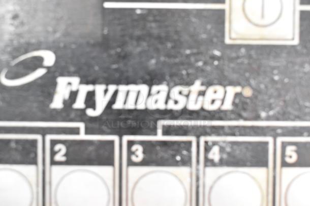 Frymaster commercial fryer control panel with logos and numbered dials visible.