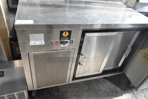 Commercial 2 Door Undercounter Cooler with stainless steel finish, vented front panel, and label for covered food. Good condition.