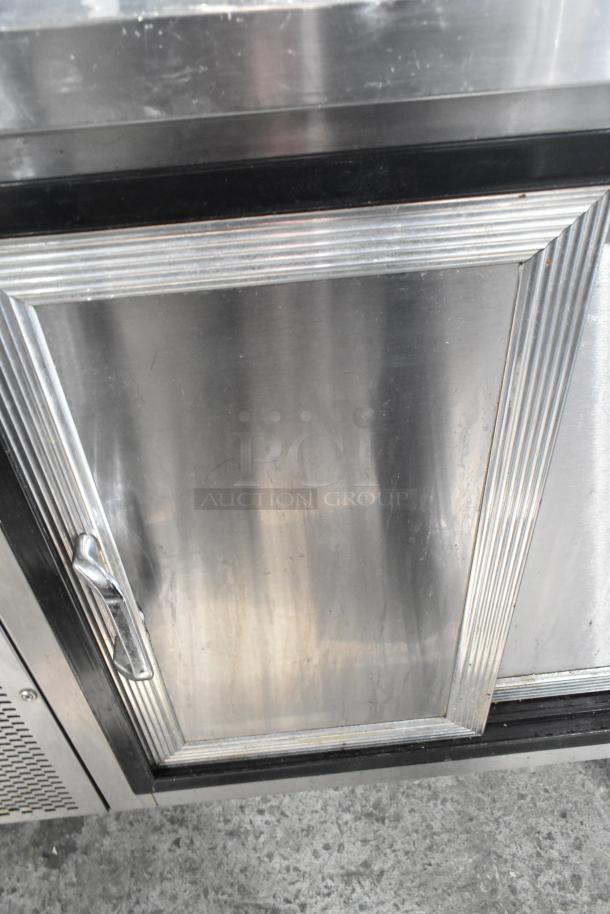 Commercial 2 Door Undercounter Cooler, stainless steel exterior, ribbed door design, visible handle, good condition.