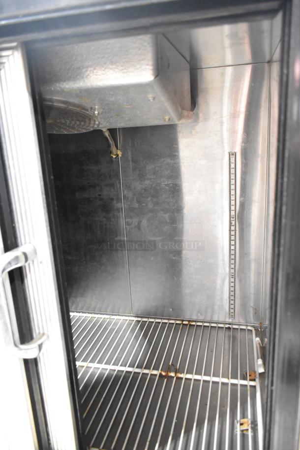 Commercial 2 Door Undercounter Cooler, stainless steel interior, wire shelving, visible wear, ideal for restaurant use.