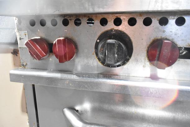 Vulcan commercial gas range knobs, showing red burner controls and black oven timer dial on stainless steel surface.