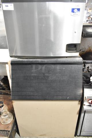 Manitowoc commercial ice machine head on black ice bin, stainless steel, model label visible, good condition.