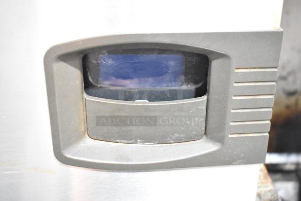 Manitowoc commercial ice machine head on bin, stainless steel, front control panel visible, used condition.