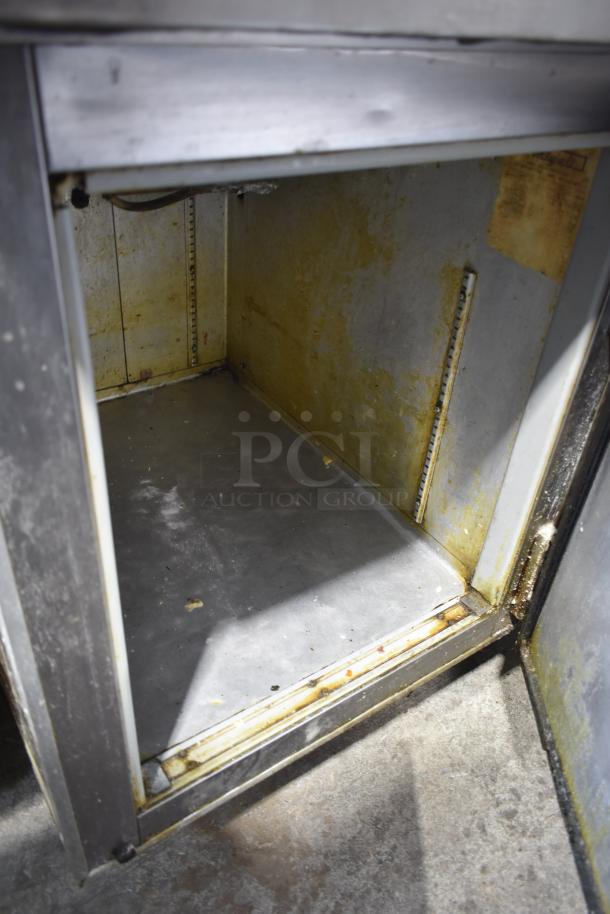 Migali Commercial Pizza Prep Table interior, 115 volts, showing used condition with visible wear and staining.