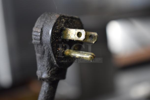 Power plug detail of Migali Commercial Pizza Prep Table, 115 volts, 1 phase, showing signs of use.