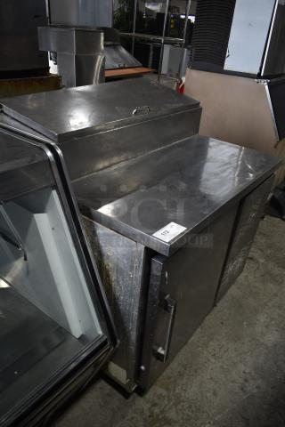 Migali commercial pizza prep table in stainless steel. Features include a single door, 115 volts, 1 phase. Visible wear.
