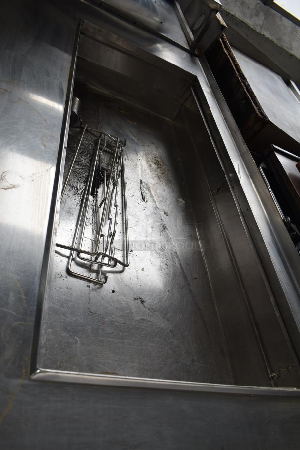 Commercial prep station with stainless steel surface on commercial casters, showing signs of wear and use.