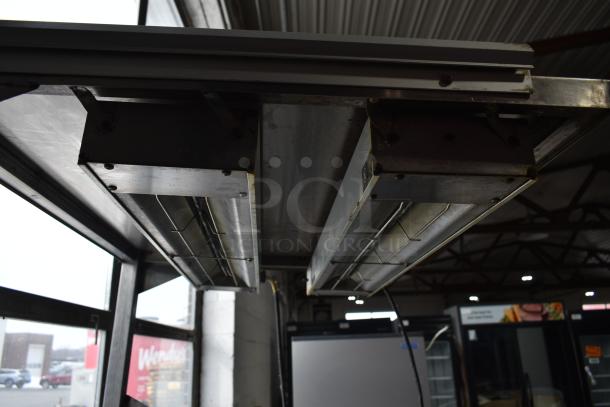 Commercial multi-shelf merchandiser display with warming strips, in used condition. Features stainless steel construction and visible wiring.