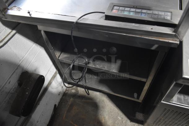 Commercial multi-shelf merchandiser display with warming strips, featuring shelves and control panel. Moderate wear visible.