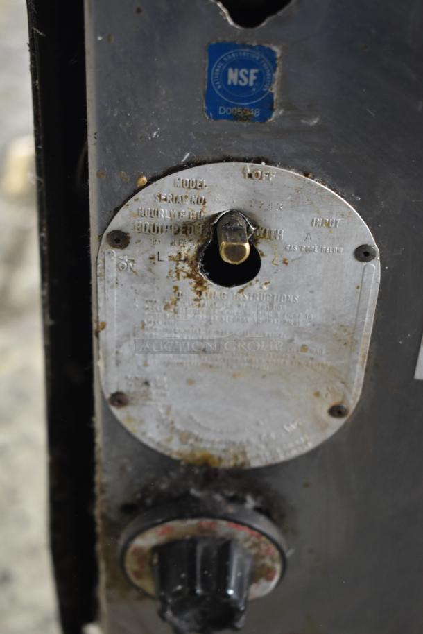 2 Bakers Pride gas pizza ovens with NSF sticker, model info, and control knob. Shows moderate wear.