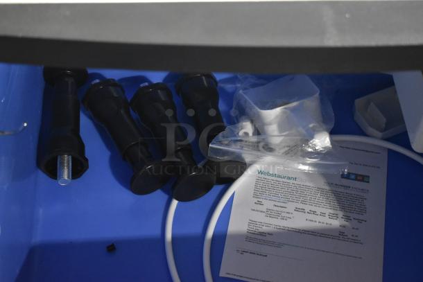 Components for Avantco 194UCF280A ice machine, including adjustable feet and a WebstaurantStore document on a blue surface.