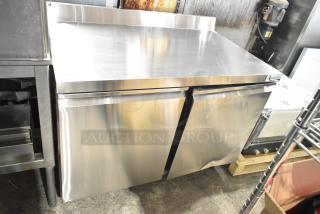 Brand new Avantco 178SSWT48FHC commercial 2-door undercounter freezer with casters, slight dent, stainless steel finish.