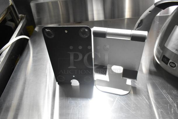 Seven assorted items, featuring a coffee pot and a credit card reader, on a reflective metal surface. Items in good condition.