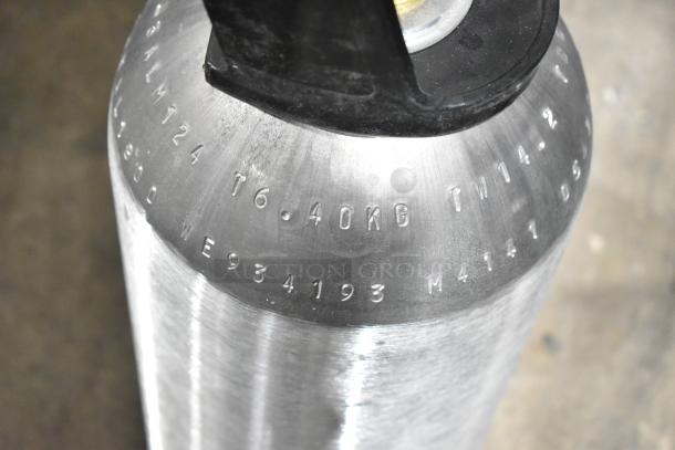 Three CO2 tanks with engraved markings, 6.40kg capacity, silver finish, black valve. Buyer pick-up only, no shipping.