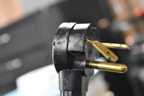 Close-up of the power plug for a 2025 Amana RC30S2 commercial microwave, showing signs of wear.