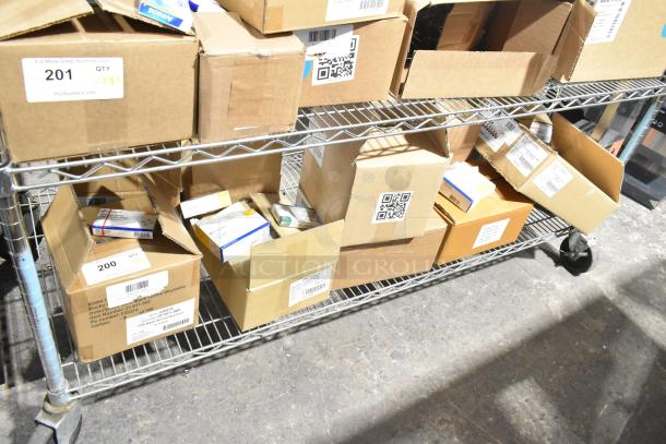 Boxes of medical supplies on a metal shelf, including gauze, masks, and gloves. Some boxes labeled with QR codes and item numbers.