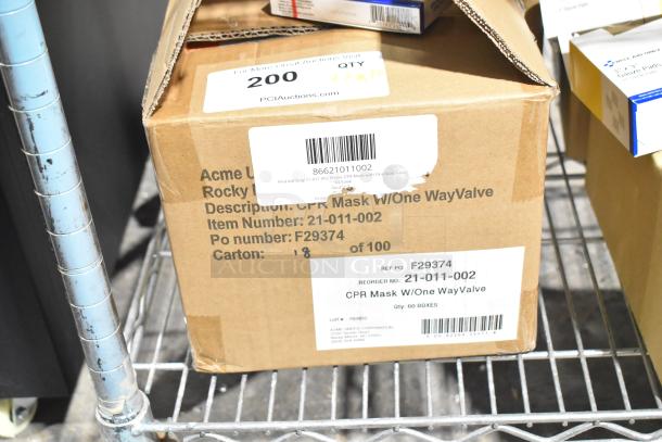 Cardboard box labeled "CPR Mask w/One Way Valve." Item Number: 21-011-002, 60 qty boxes. Contains gauze, masks, gloves. Scratched/dented.