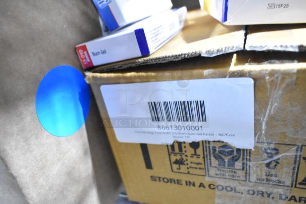 Brand new scratch and dent boxes containing gauze, masks, gloves, burn gel packets. Barcode visible.
