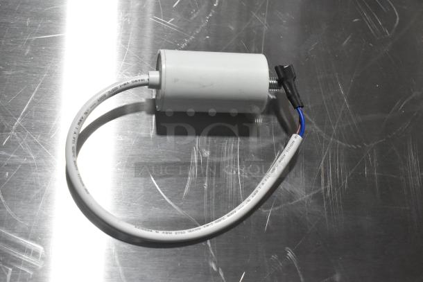 Brand new capacitor with attached wiring, minor scratch on surface. Markings indicate 600V, 105°C max temperature.