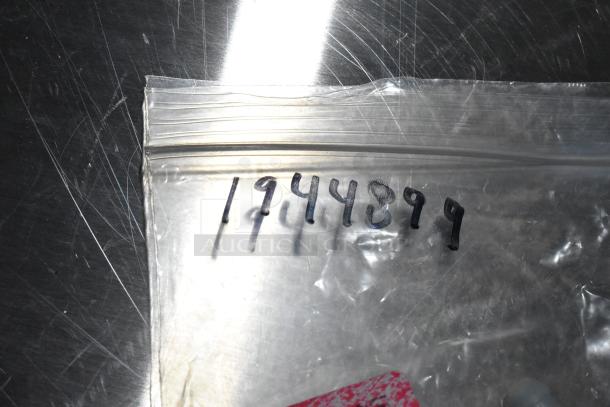 Plastic bag with handwritten number "194489" containing new scratch and dent items, including a capacitor and inlet valve.