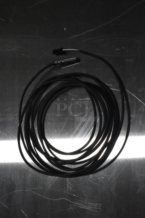 Coiled black cable with connectors, part of a lot including hinge, probe, and knob. New scratch and dent items.