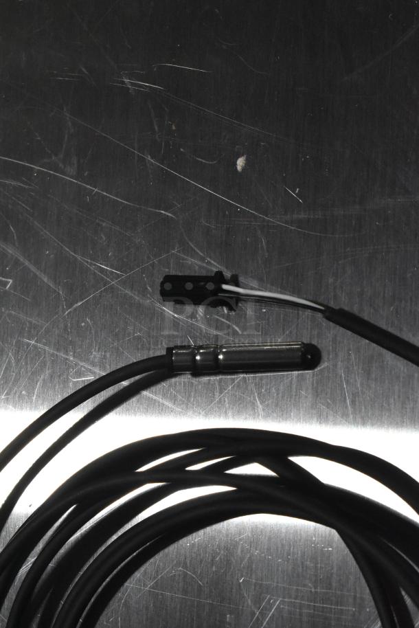 Coiled black cable with connector and probe, new condition, part of a 5-item scratch and dent auction set.