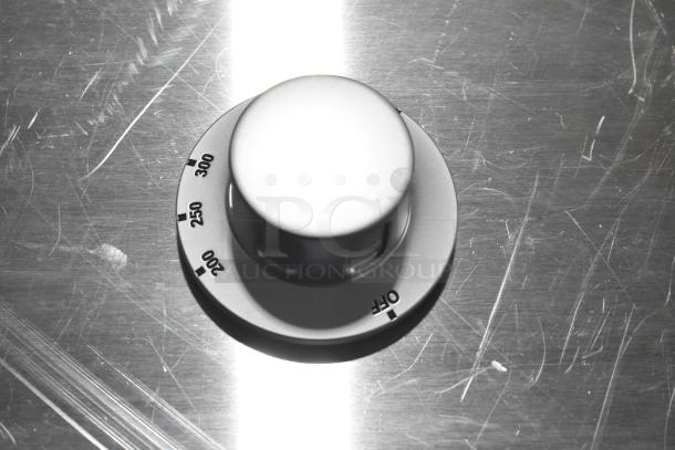 Stainless steel temperature knob with settings from 200 to 300 degrees. Scratch and dent condition, visible markings.