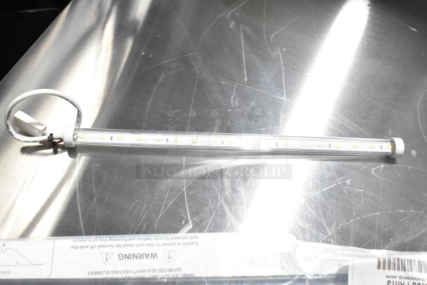 LED light strip with attached power cord on a reflective surface. Marked as brand new, labeled with a warning for heating elements.