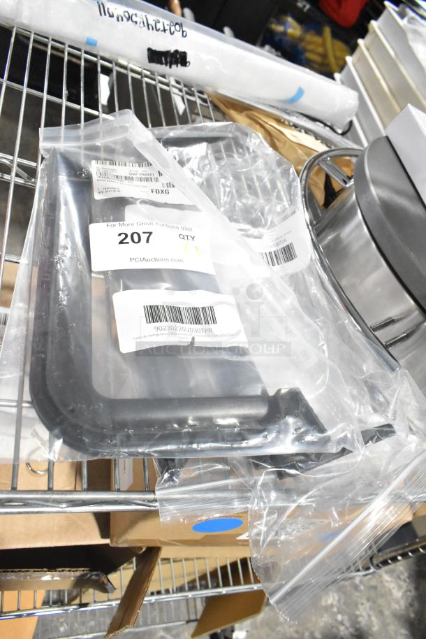 Packaged door handles, brand new with minor scratches and dents, displayed on a metal shelf. Labels include auction details and item codes.