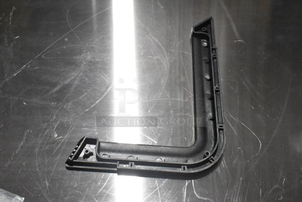 Plastic door handle component on metal surface, part of scratch and dent auction items, new condition, black color.