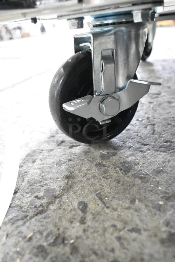 Caster wheel of a brand new Avantco 178SSPT488 prep table, showing metal and rubber construction with brake.