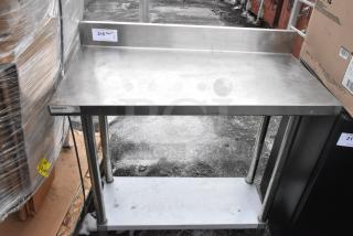 Regency 600TB1838G stainless steel table with backsplash and under shelf, moderate wear, label on front.