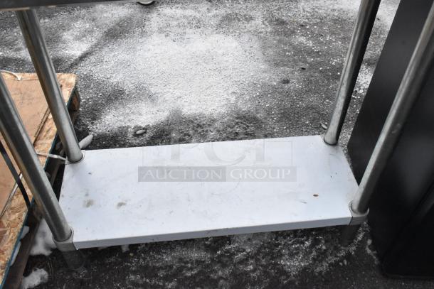 Regency 600TB1838G stainless steel table, visible under shelf and legs, snowy backdrop, slight wear visible.